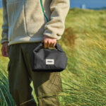 Personne tenant un petit sac noir en plein air