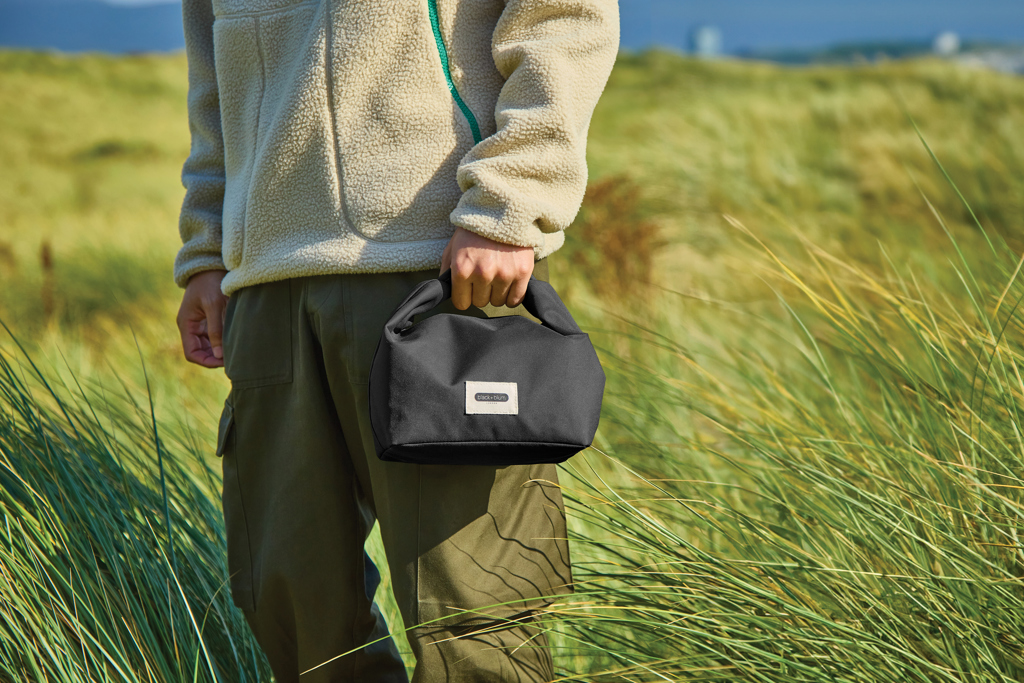 Personne tenant un petit sac noir en plein air
