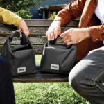 Deux personnes avec sacs noirs sur un banc