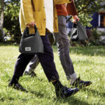 Deux personnes marchent avec des sacs noirs