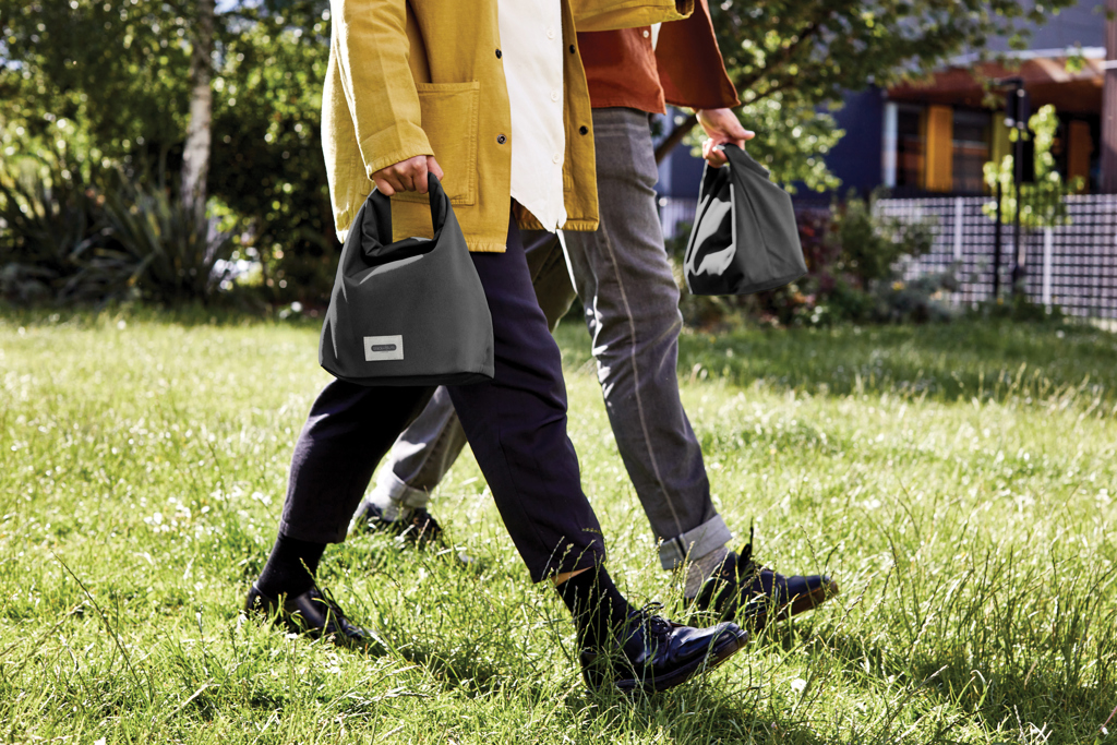 Deux personnes marchent avec des sacs noirs