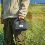 Personne tenant un petit sac noir en plein air