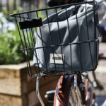 Sac gris dans panier arrière de vélo.