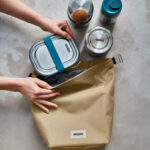 Préparation d’un sac avec boîtes repas réutilisables.