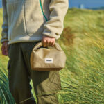 Personne tenant un sac beige dans la nature