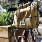 Sac beige dans panier arrière de vélo