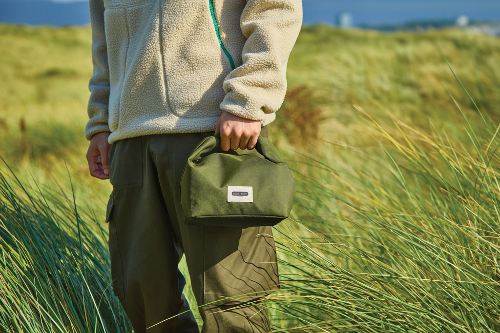 Personne tenant un sac vert en plein air