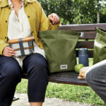 Pique-nique sur un banc avec sacs isothermes verts