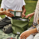 Personnes pique-niquant avec sac isotherme vert.