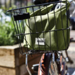 Sac vert dans panier arrière de vélo urbain