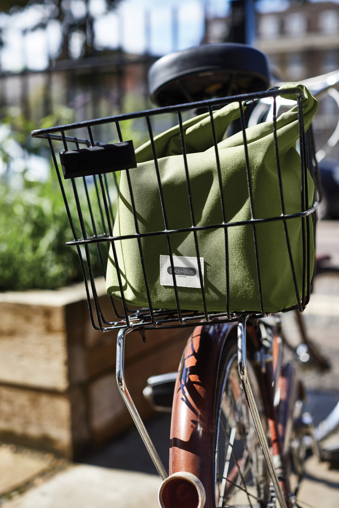 Sac vert dans panier arrière de vélo urbain