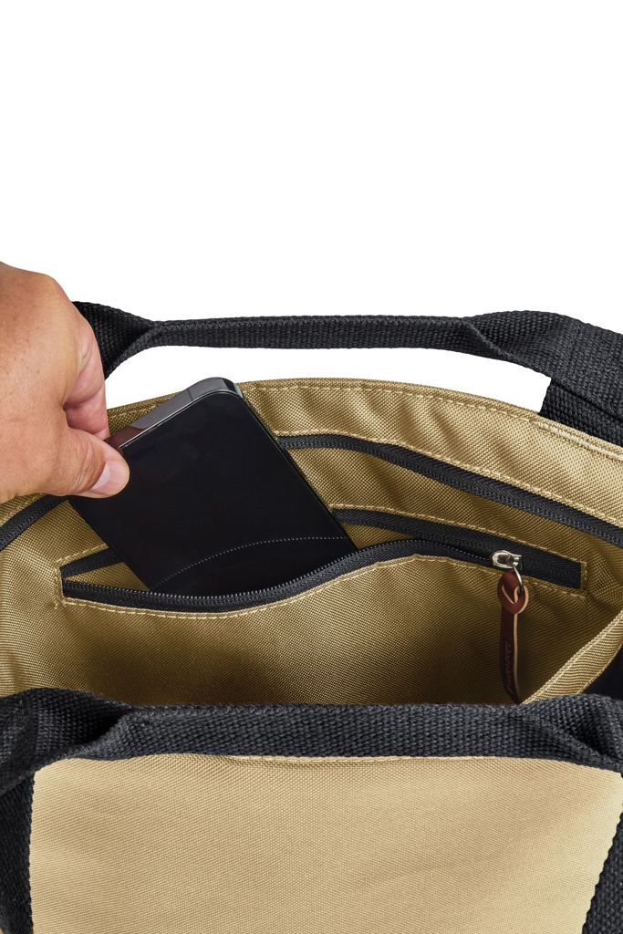 Main mettant un smartphone dans un sac beige