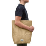 Homme portant un grand sac beige épaule