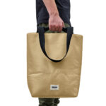 Personne tenant un grand sac beige à anses noires