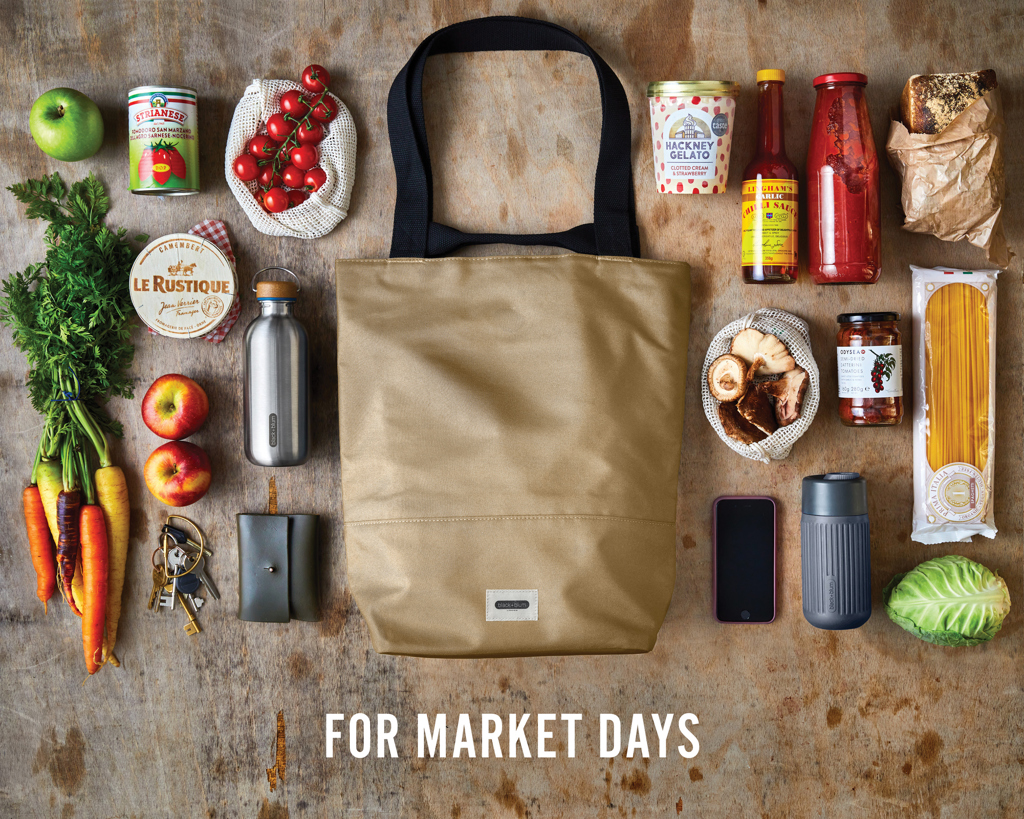 Sac de marché entouré de produits et légumes frais