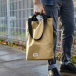 Personne tenant un sac beige en tissu