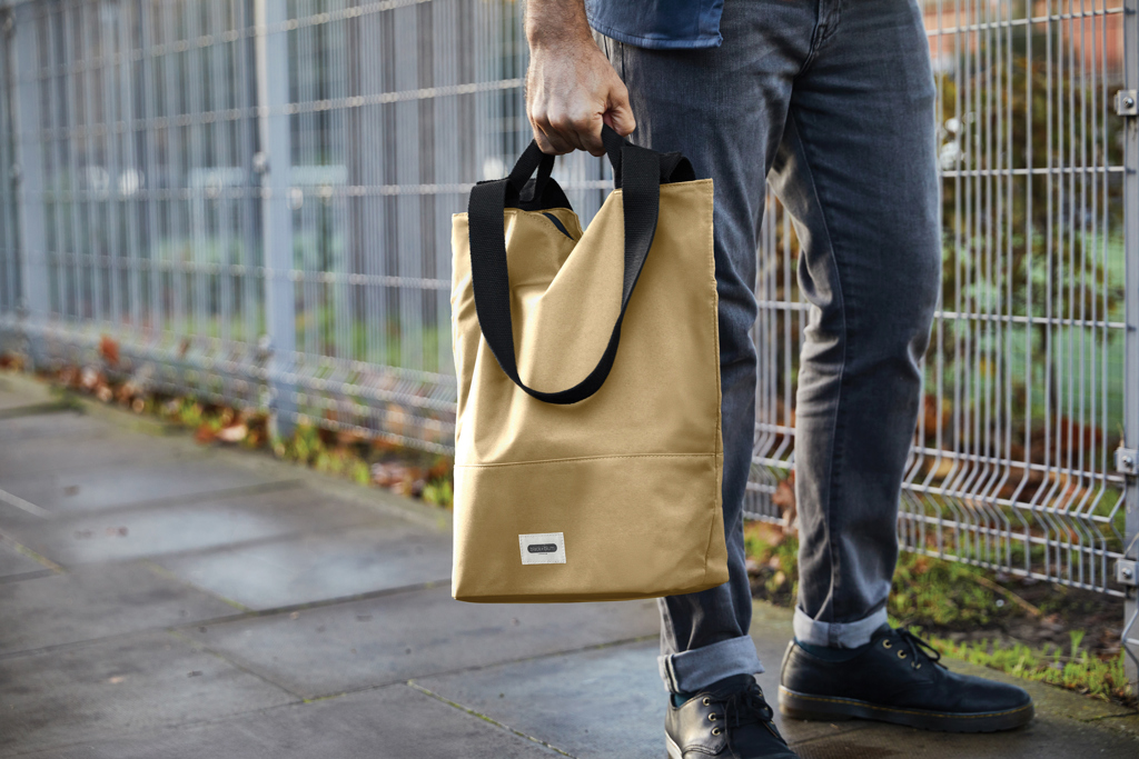 Personne tenant un sac beige en tissu