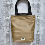 Sac beige entouré de bouteilles plastiques recyclées