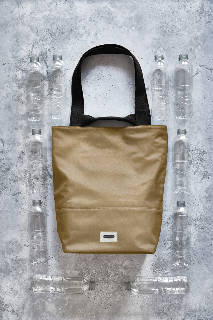 Sac beige entouré de bouteilles plastiques recyclées