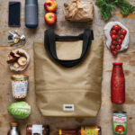 Sac de courses avec aliments frais et produits variés.