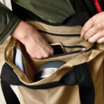 Main prenant un téléphone dans un sac beige