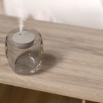 Diffuseur d'arômes en verre sur table en bois