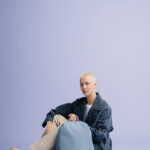 Personne assise avec un sac à dos bleu.