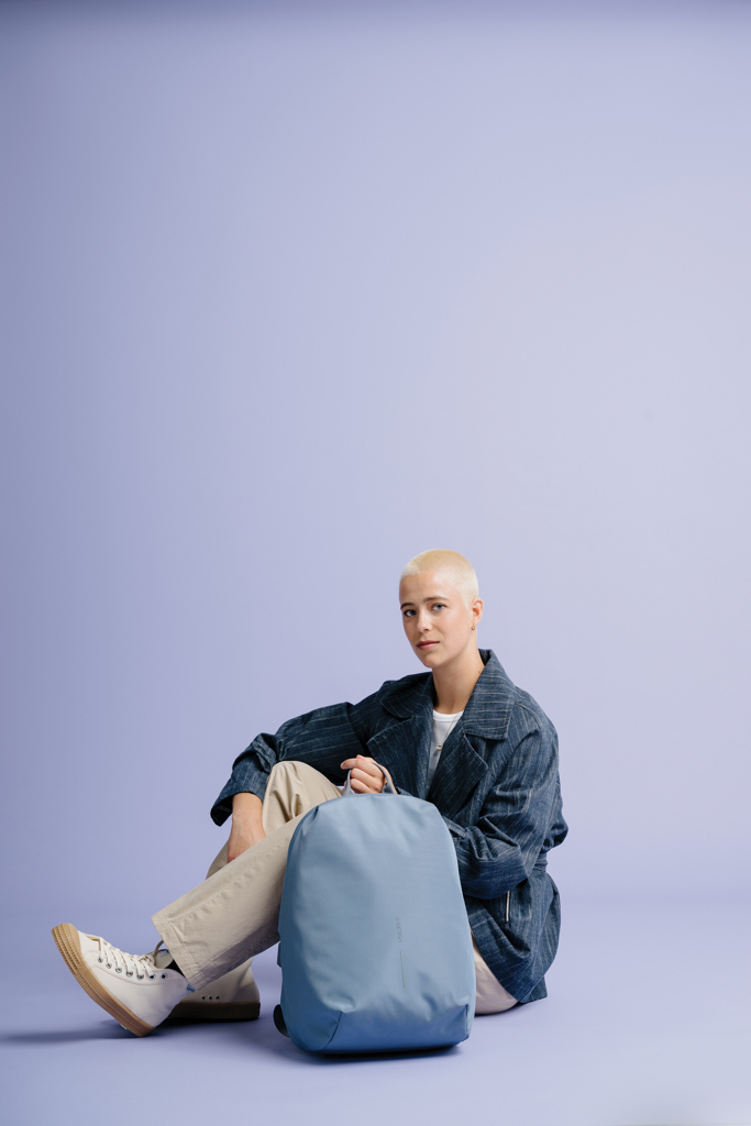 Personne assise avec un sac à dos bleu.