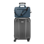 Valise grise avec sac bleu posé dessus