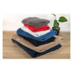 Pile de serviettes colorées pliées sur table.