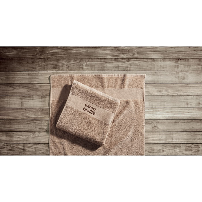 Serviettes beiges pliées sur plancher en bois.