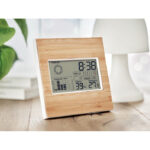Station météo numérique en bois sur table.