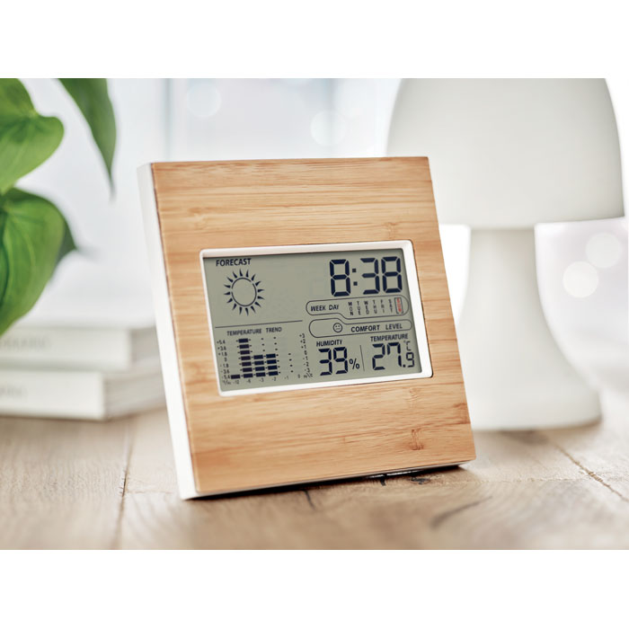 Station météo numérique en bois sur table.