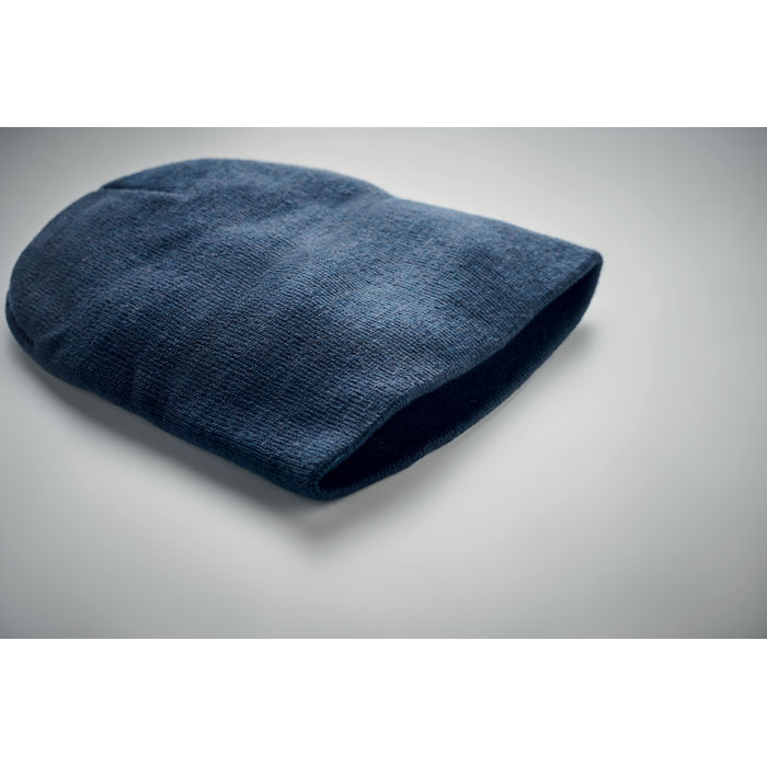 Bonnet en laine bleu posé sur surface grise