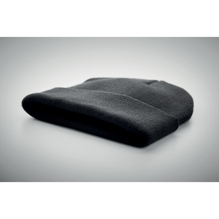 Bonnet noir en laine plié sur fond gris