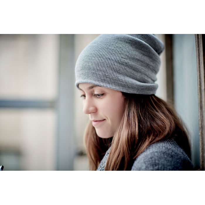 Femme portant un bonnet gris près d'une fenêtre