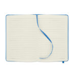 Carnet ouvert avec ruban bleu et lignes.