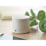 Enceinte Bluetooth beige sur une table en bois