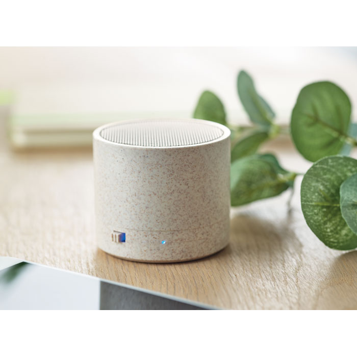 Enceinte Bluetooth beige sur une table en bois