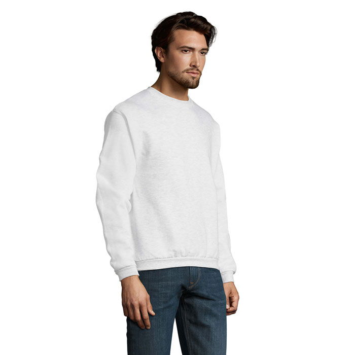 Homme portant un sweat blanc et un jean.
