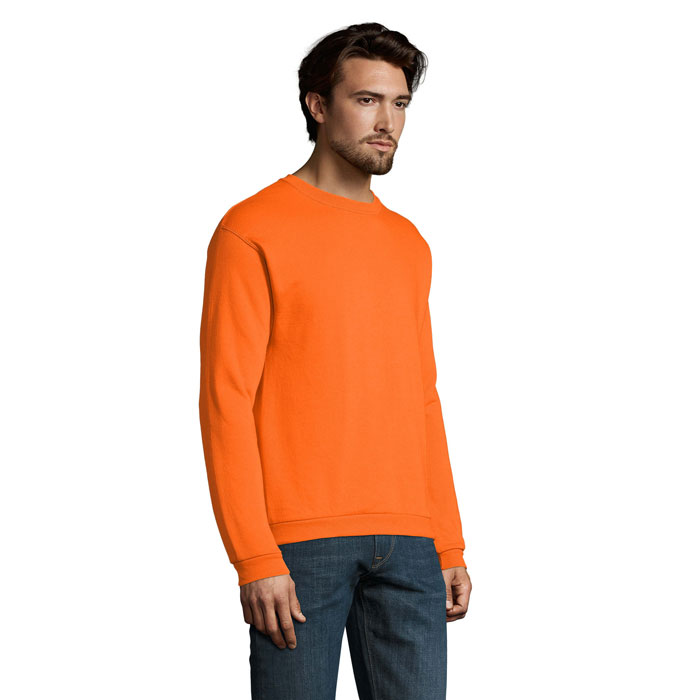 Homme portant un sweat orange et un jean