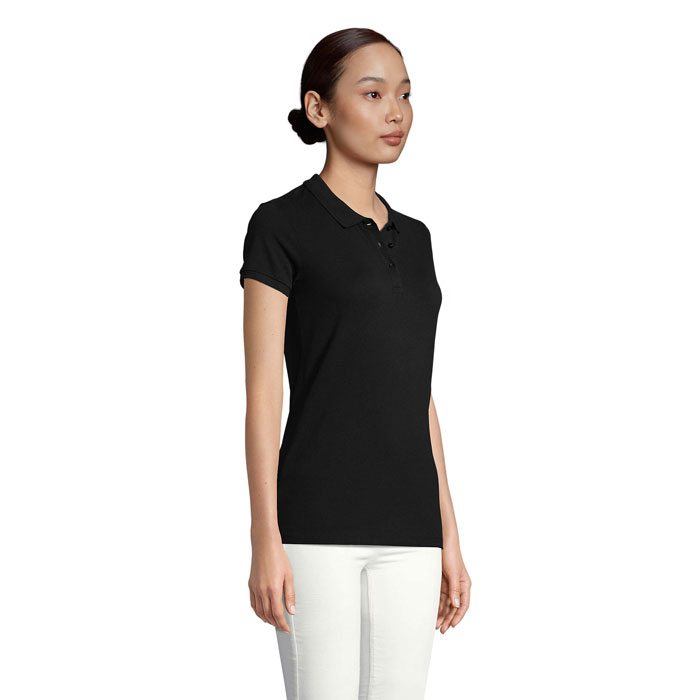 Femme portant un polo noir et pantalon blanc