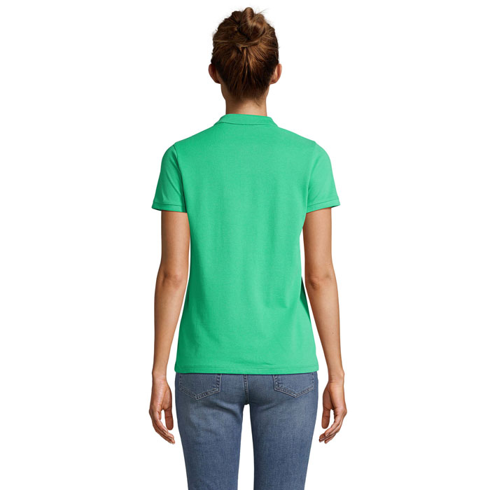 Femme portant un polo vert et un jean.
