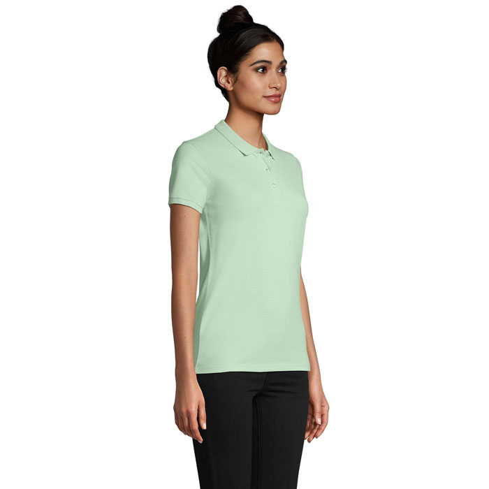 Femme portant un polo vert clair et pantalon noir