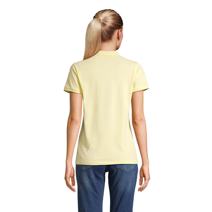 Femme portant un polo jaune et un jean bleu