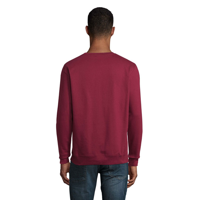 Homme portant un sweat bordeaux et un jean bleu