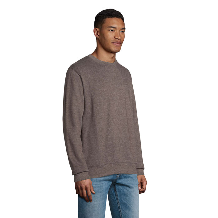 Homme portant un sweat marron et un jean bleu