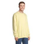 Homme portant un sweat jaune et un jean bleu