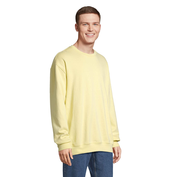Homme portant un sweat jaune et un jean bleu