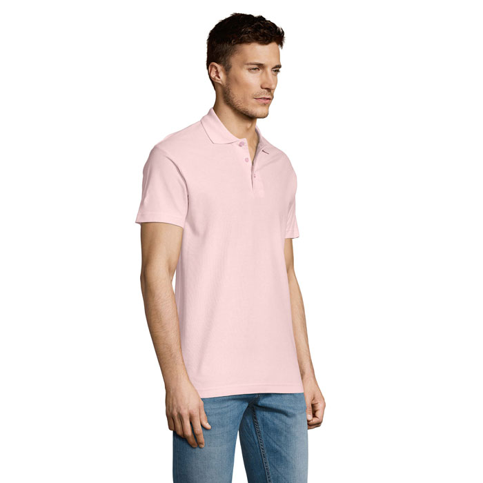Homme portant un polo rose pâle et jean